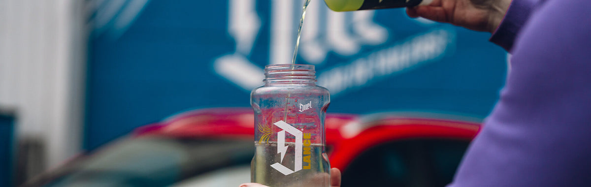 Assault Snow Foam concentrate being poured into a Duel foam lance bottle — showing correct dilution measurement