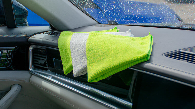 Folded general purpose microfibre cloths stacked on dashboard — interior and general use