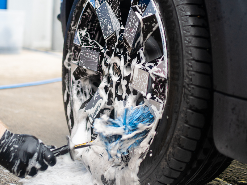 Wheel brush being used to agitate wheel cleaner