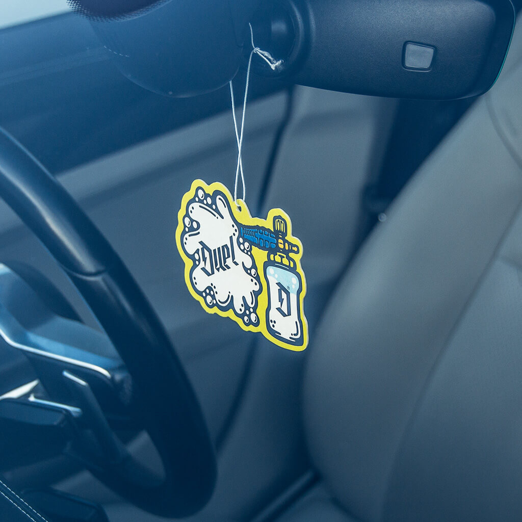Premium hanging air with baccarat rouge scent hanging from the review mirror of a car