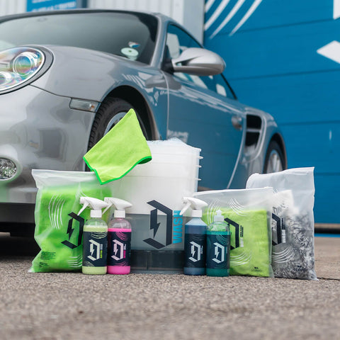 Car Detailing Bucket Starter Kit next to porsche
