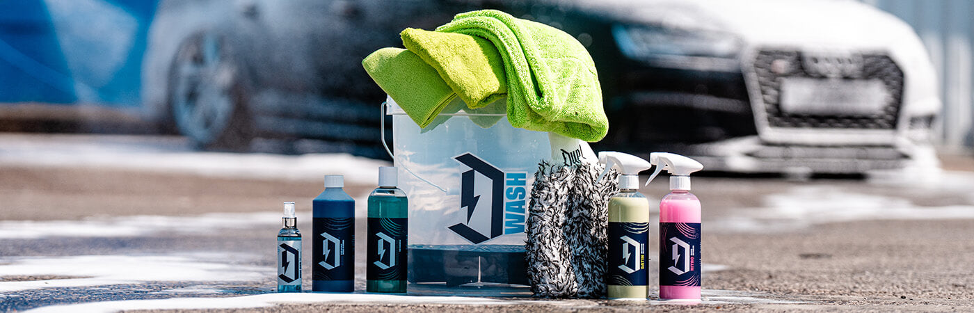 A complete no-hose car washing kit laid out on a driveway