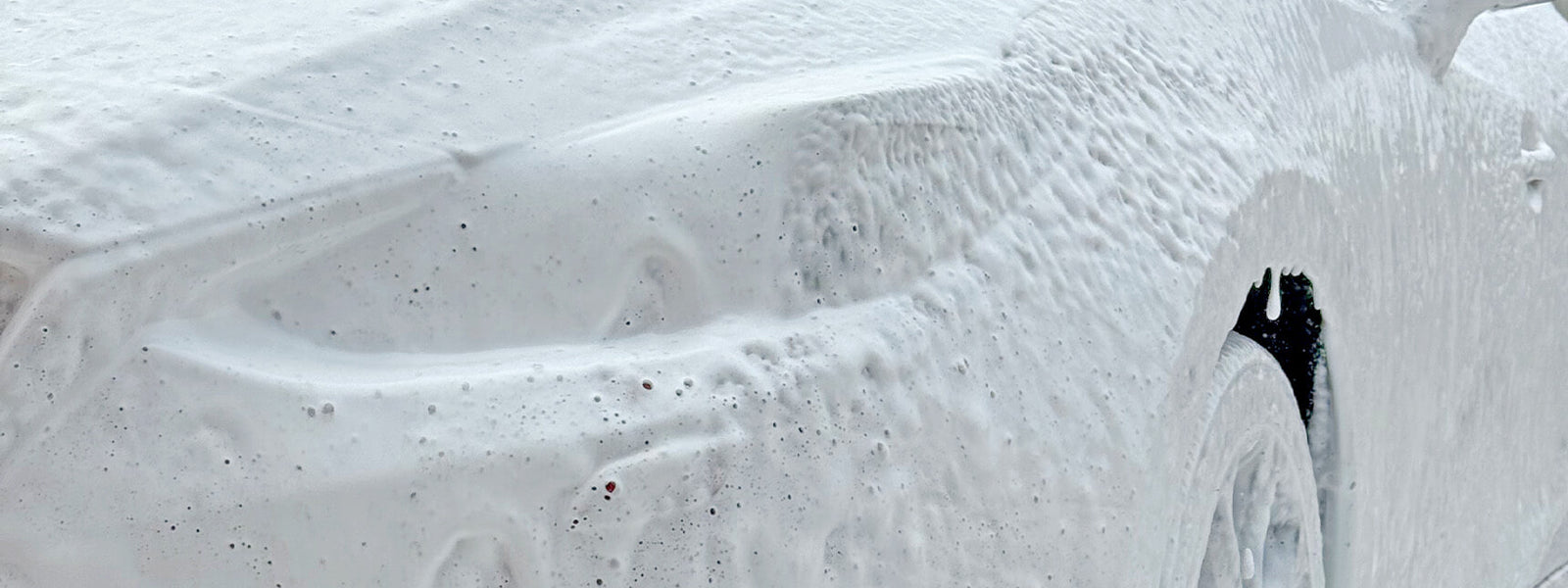 Snow foam lance applying thick foam to car paintwork