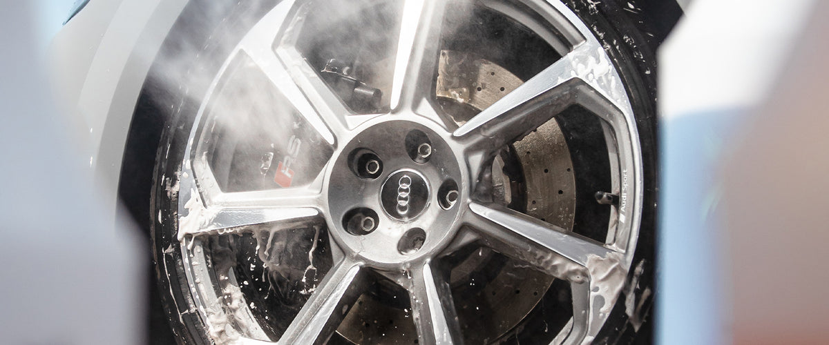 Wheel being rinsed with a pressure washer