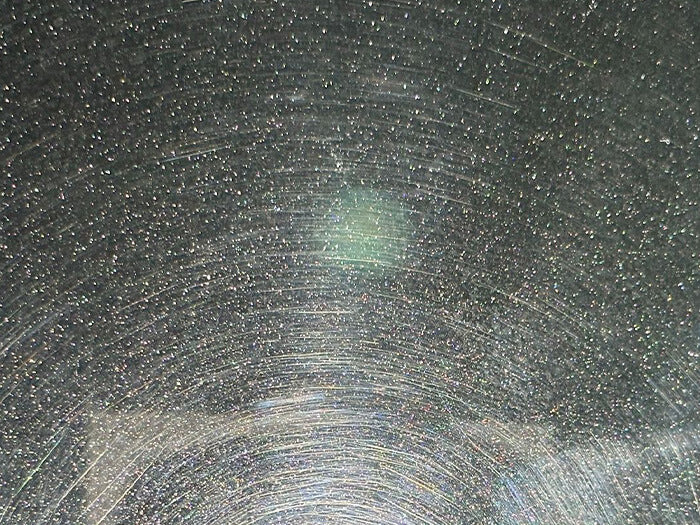 Close-up of swirl marks on paint caused by incorrect wash media — dragging dirt across unprotected paint