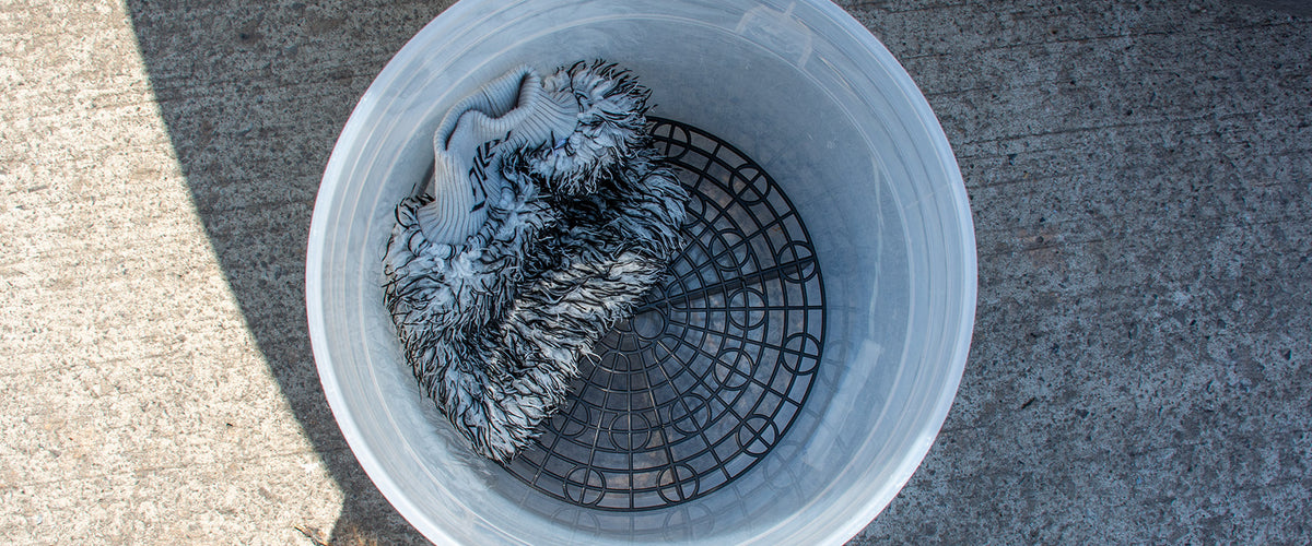 Grit guard at the base of a wash bucket